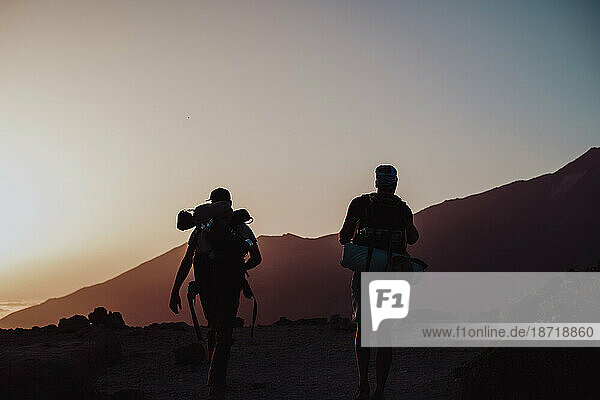 Hikers walking at sunset in Guajara mountain in El Teide