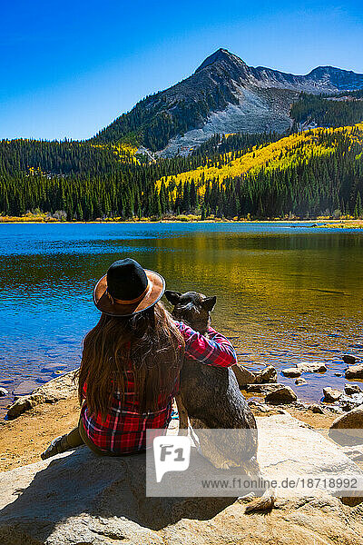Girl and Dog Hugging at Colorado Mountain Lake in Autumn