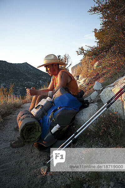A hiker checks his IPhone along the Tahoe Rim Trail