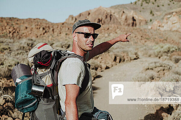 A hiker points out the way to go on the mountain  El Teide  Tenerife