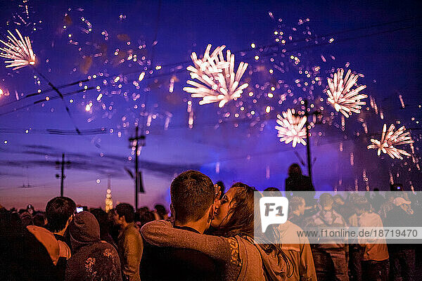Young Couple Kissing Under Fireworks
