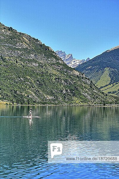 A lady paddle boards on a lake in Chile