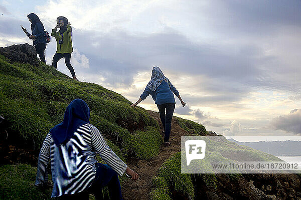 Women traveling on path up hill