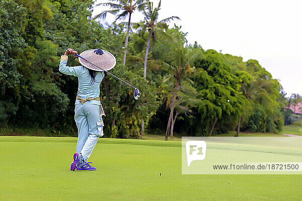 Rear view of Asian woman playing golf