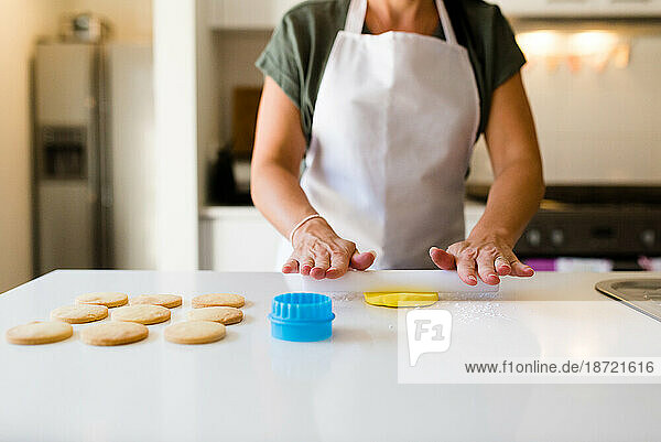 A female baker's hands decorating cookies in her kitchen