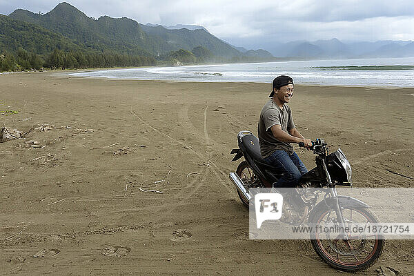 Asian man on motorcycle on beach  Banda Aceh  Sumatra  Indonesia