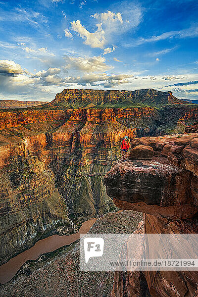 Woman standing on Cliffside looking out over the Grand Canyon