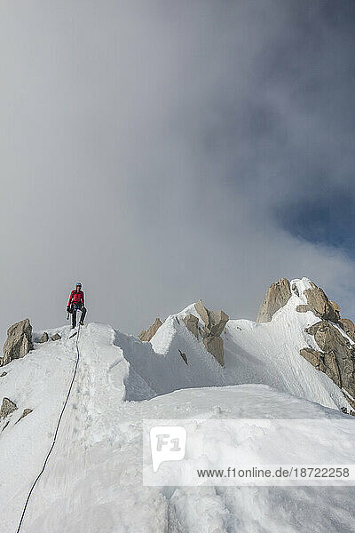 An alpinist poses on a ridge after summiting Aiguille du Chardonnet