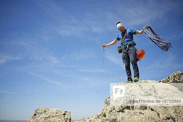 Climber picking up the rope at the summit of Palomera Peak.