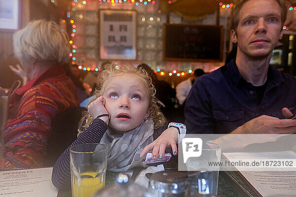 father and daughter sitting together in restaurant waiting for food