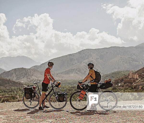 A couple of cyclists look at the view of the Atlas Mountains  Morocco