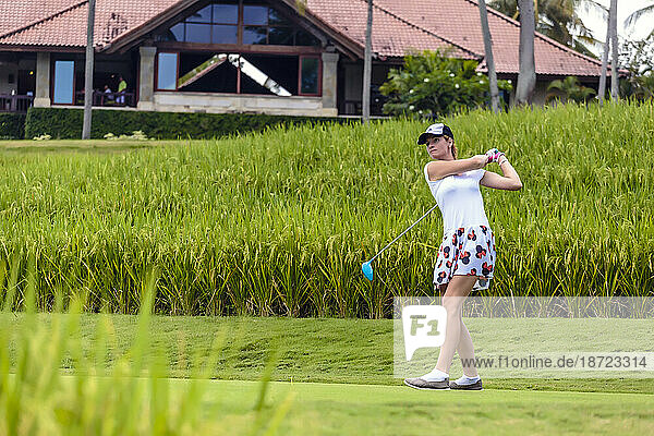 Front view of young woman playing golf