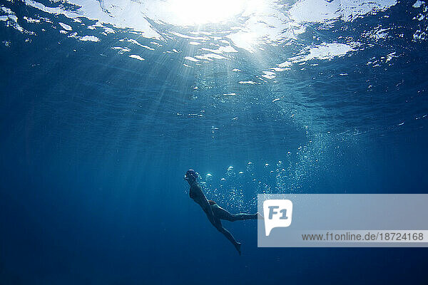 A swimmer leaves a trail of bubbles as she enjoys the warm tropical waters off Mana Island  Fiji.