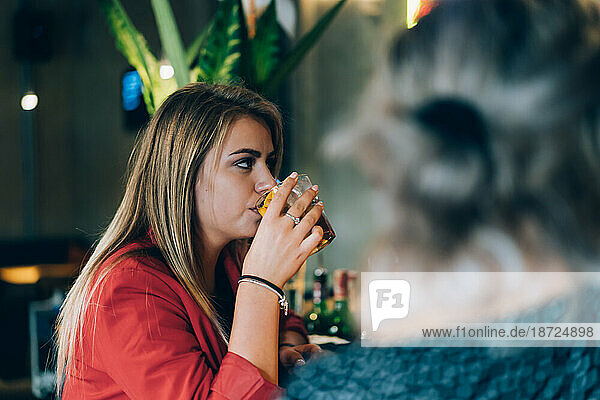 Blonde Girl Having A Drink In A Cocktail Bar.