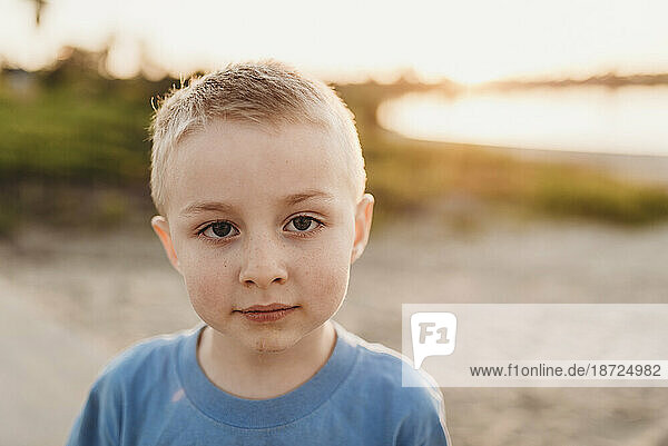 Portrait of school-aged boy at the beach during sunset in backlight