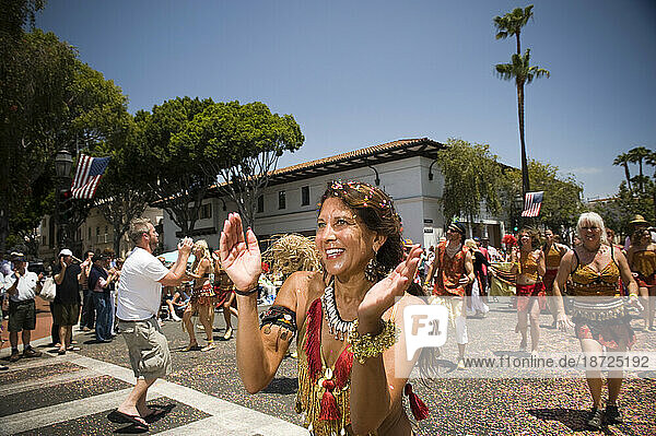 Revelry and happiness at a parade in Santa Barbara. The parade features extravagant floats and costumes.