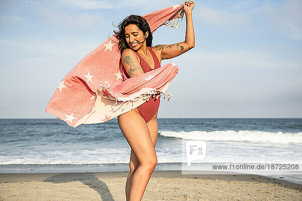 Latina woman having fun at the beach with towel