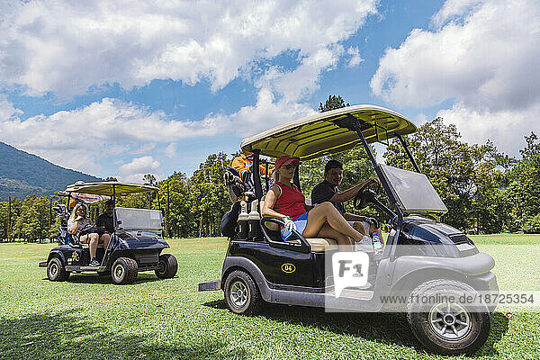 Golfers in golf carts on golf course  Bedugul  Bali  Indonesia