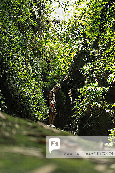 Traveler woman with a backpack in the jungle of Bali.
