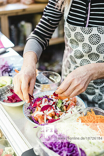 Woman preparing salad in a vegan restaurant
