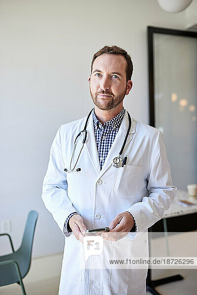 Portrait of male healthcare worker wearing lab coat while standing