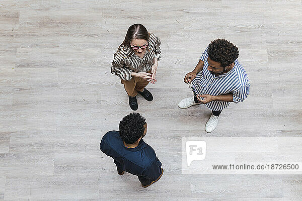 High angle view of business colleagues talking on wooden floor
