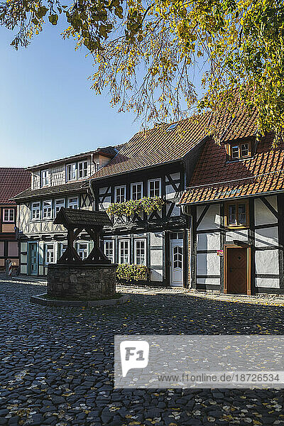 Germany  Saxony-Anhalt  Wernigerode  Half-timbered townhouses along cobblestone street with well in foreground