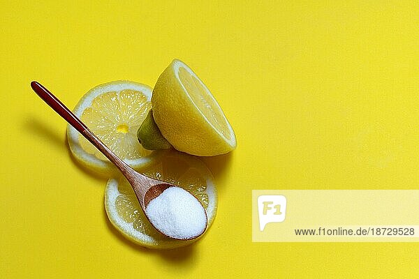Zitronensäure in Holzlöffel und Zitrone