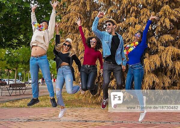 Gruppe multiethnischer Freunde  die in einem Park feiern  Verschiedene junge Leute  die bei einer Sommerparty vor Freude springen  Happy Hour  Mittagspause und Jugendkonzept