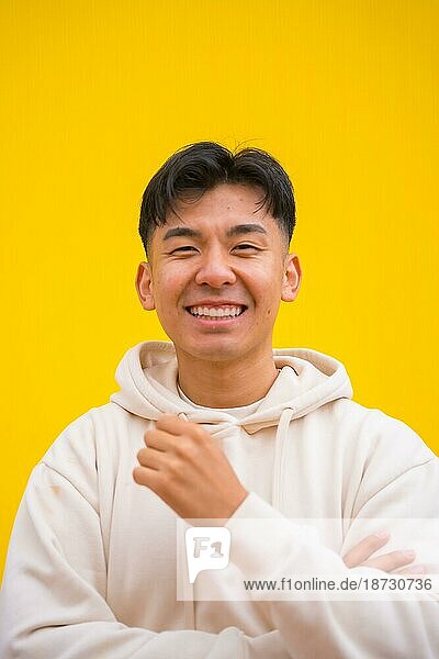 Porträt eines gut aussehenden südkoreanischen asiatischen Mannes in einfacher Kleidung  lächelnd  isoliert auf gelbem Hintergrund  lächelnd und Spaß habend