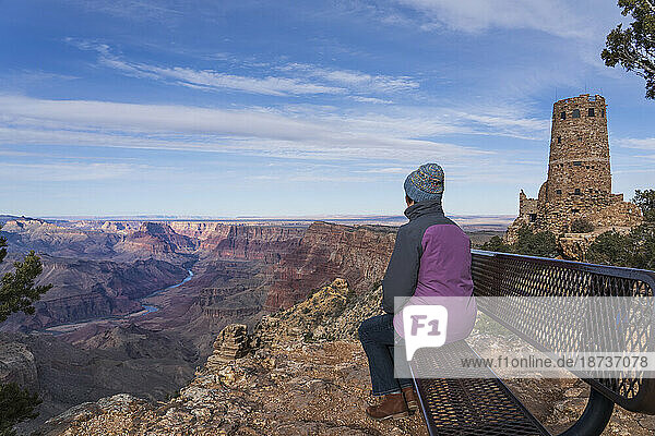 USA  Arizona  Rear view of female tourist sitting on bench in Grand Canyon National Park