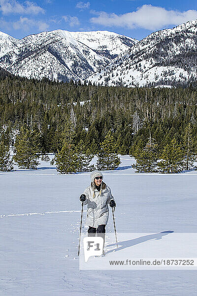 USA  Idaho  Sun Valley  Senior woman wearing snowshoes hiking in mountains