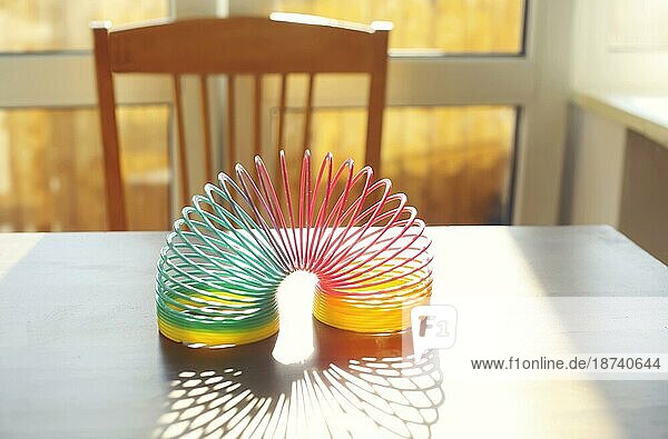 Anti Stress Magie Ring Frühling Regenbogen bounce Spielzeug auf dem Tisch in sonnigen Raum zu Hause  selektiven Fokus. Stressabbau und Anti Angst Spielzeug Konzept