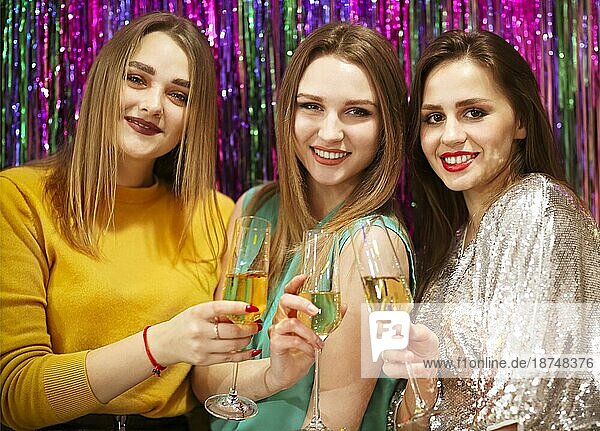 Weibliche Freunde stoßen mit Gläsern Wein an und haben Spaß auf einer Luxusparty