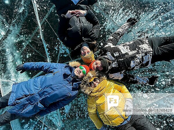 Gruppe von glücklichen Touristen Freunde auf dem Hintergrund der Eis Wintersee Baikal am sonnigen Tag. Winter Baikalsee  Russland. Konzept der Freiheit  Reisen und Glück