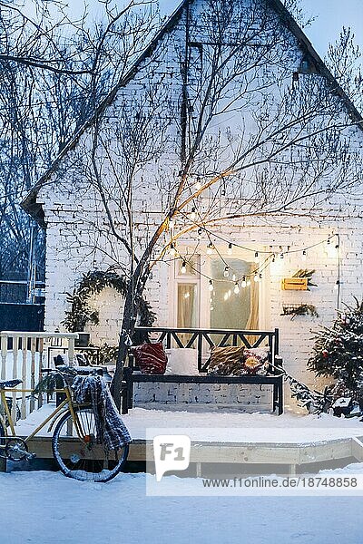 Home porche mit schneebedeckten Zweigen eines Weihnachtsbaums dekoriert. Weihnachtsdekoration  verschneite Stimmung  WinterStillleben