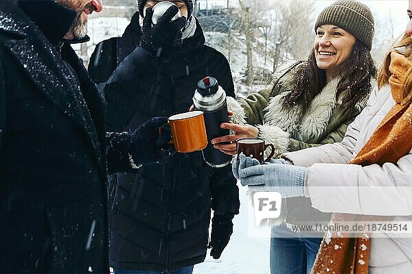 Menschen in einem Wintersportort im Winterurlaub. Freunde entspannen sich  trinken heißen Kaffee. Pause nach Winteraktivität. Glückliche Ferien im Schnee Berg am See