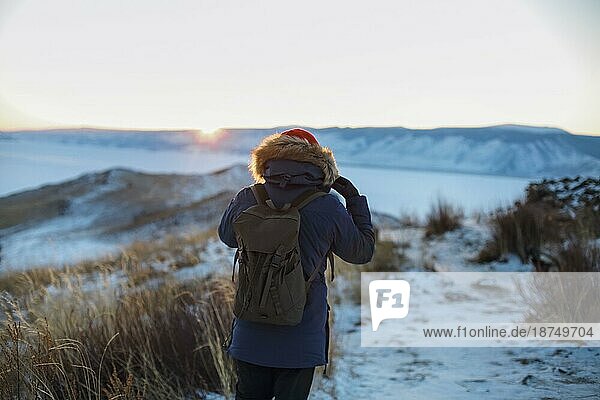 Junger Mann steht im Winter gefrorenen Natur und beobachten ruhigen Winter nebligen Sonnenaufgang. Thinking Konzept  volle Freiheit Foto  schöne Landschaft. Ogoy Insel  Baikalsee  Sibirien  Russland  Europa