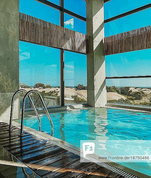 Schönes Hallenbad in einem luxuriösen Wellnesshotel oder einer Ferienvilla am Meer an einem sonnigen Tag  Strandhaus mit Panoramafenstern und Meerblick