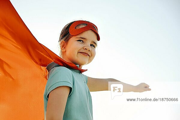 Porträt von Superhero Kind gegen blaün Himmel Hintergrund. Freude und Kindheit Konzept