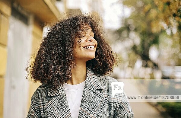 Nette Herbst Nahaufnahme Porträt der jungen lächelnd glücklich afrikanischen amerikanischen Frau mit lockigem Haar genießen Spaziergang im Park im Herbst Saison. Outdoorfoto von zufriedenen schwarzen Mädchen mit Augen in der Liebe mit dem Leben