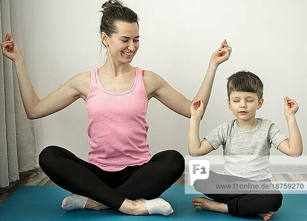 Aktive Mutter übt Yoga mit ihrem Sohn