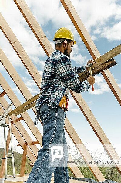 Bauarbeiter mit Schutzhelm beim Bau eines Dachhauses