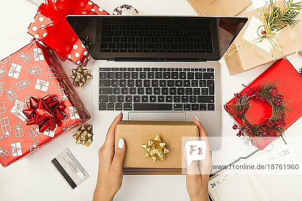 Frau hält Geschenk-Box beim Einkaufen online Tisch mit Weihnachtsdekoration. Auflösung und hohe Qualität schönes Foto