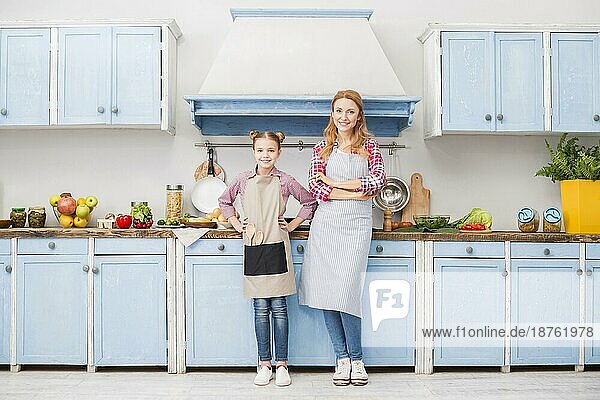 Portrait glückliche Mutter Tochter Schürze stehend Küche