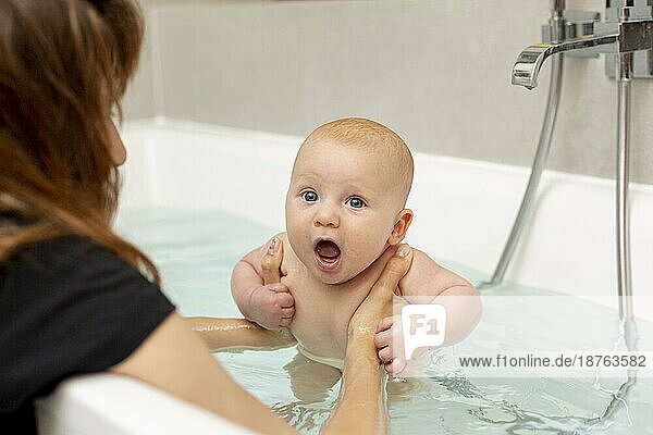 Nahaufnahme Mutter wäscht Baby in der Badewanne