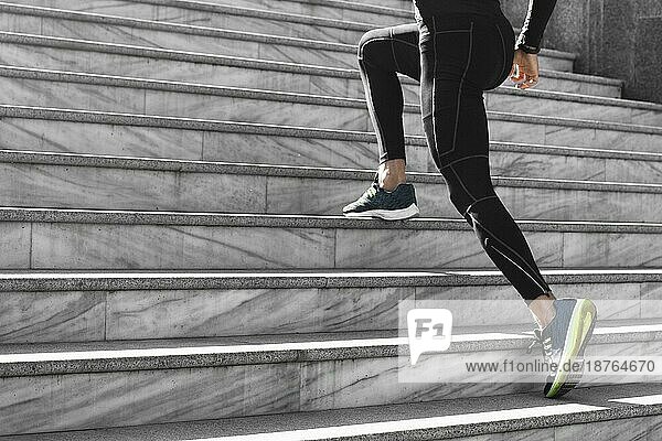Seitenansicht Mann sportliche Kleidung trainiert Treppe im Freien. Hohe Auflösung Foto