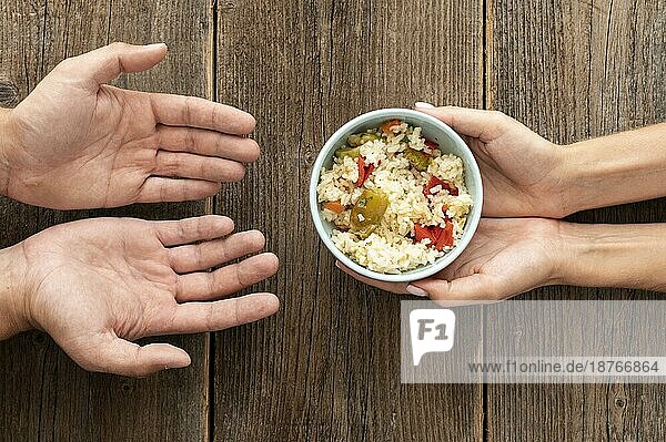 Hand gibt Schüssel Essen bedürftige Person. Foto mit hoher Auflösung
