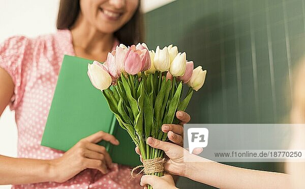 Mädchen überreicht Blumenstrauß ihrem Lehrer