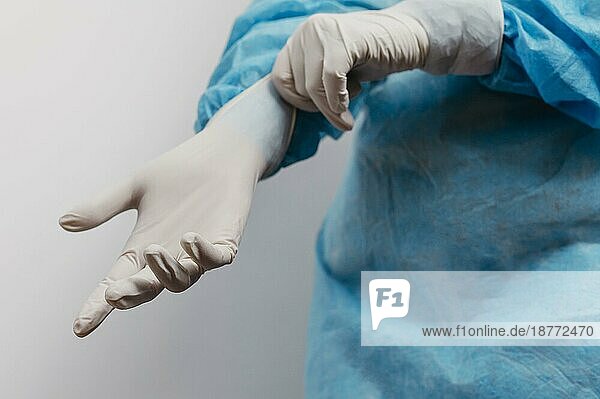 Junger Arzt mit chirurgischen Handschuhen